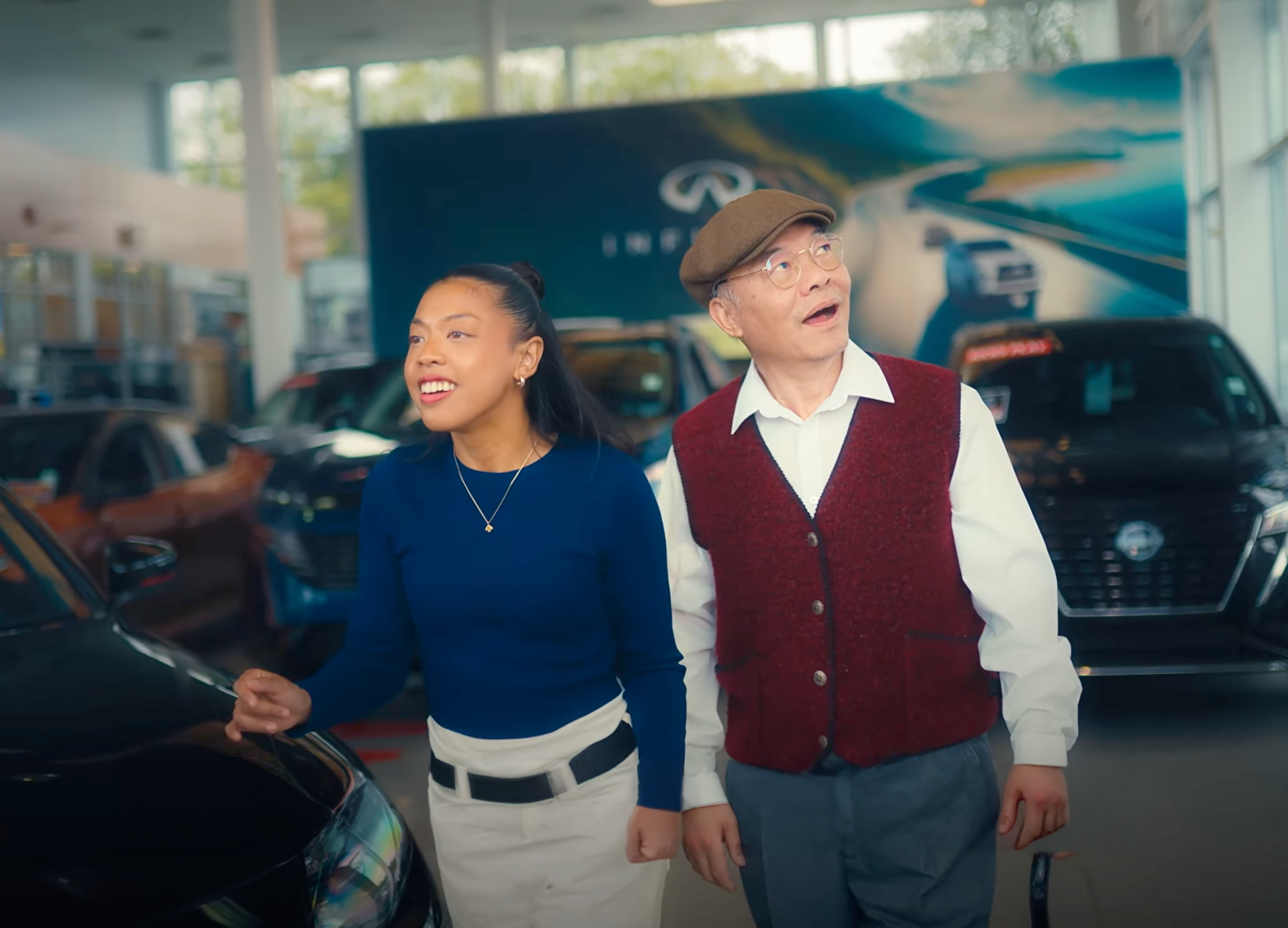 Dealer Ignition — two customers inside a luxury Infiniti dealership showroom